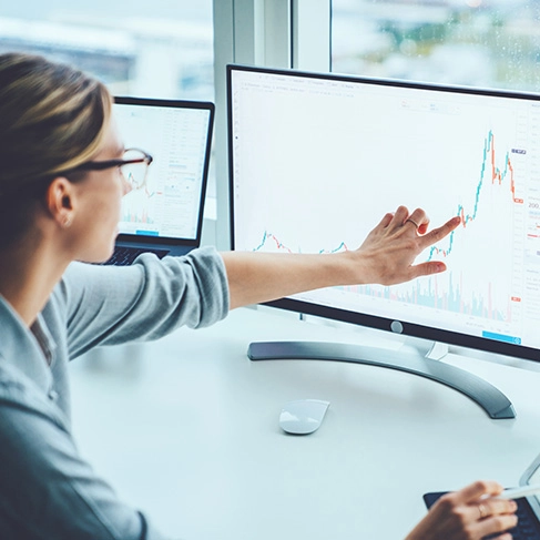 person pointing at data on a monitor